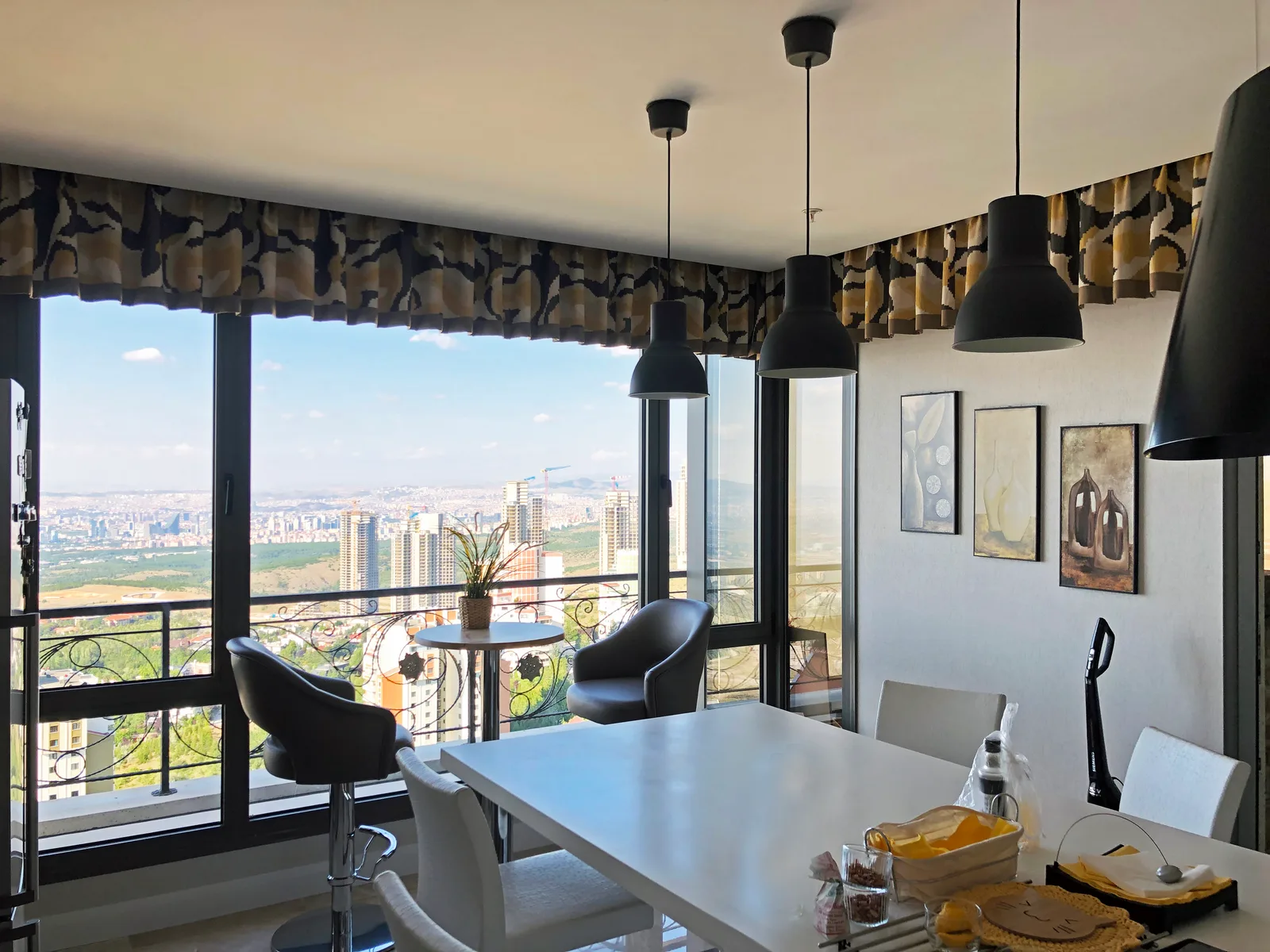 Patterned curtain valance above large windows in a kitchen and dining area