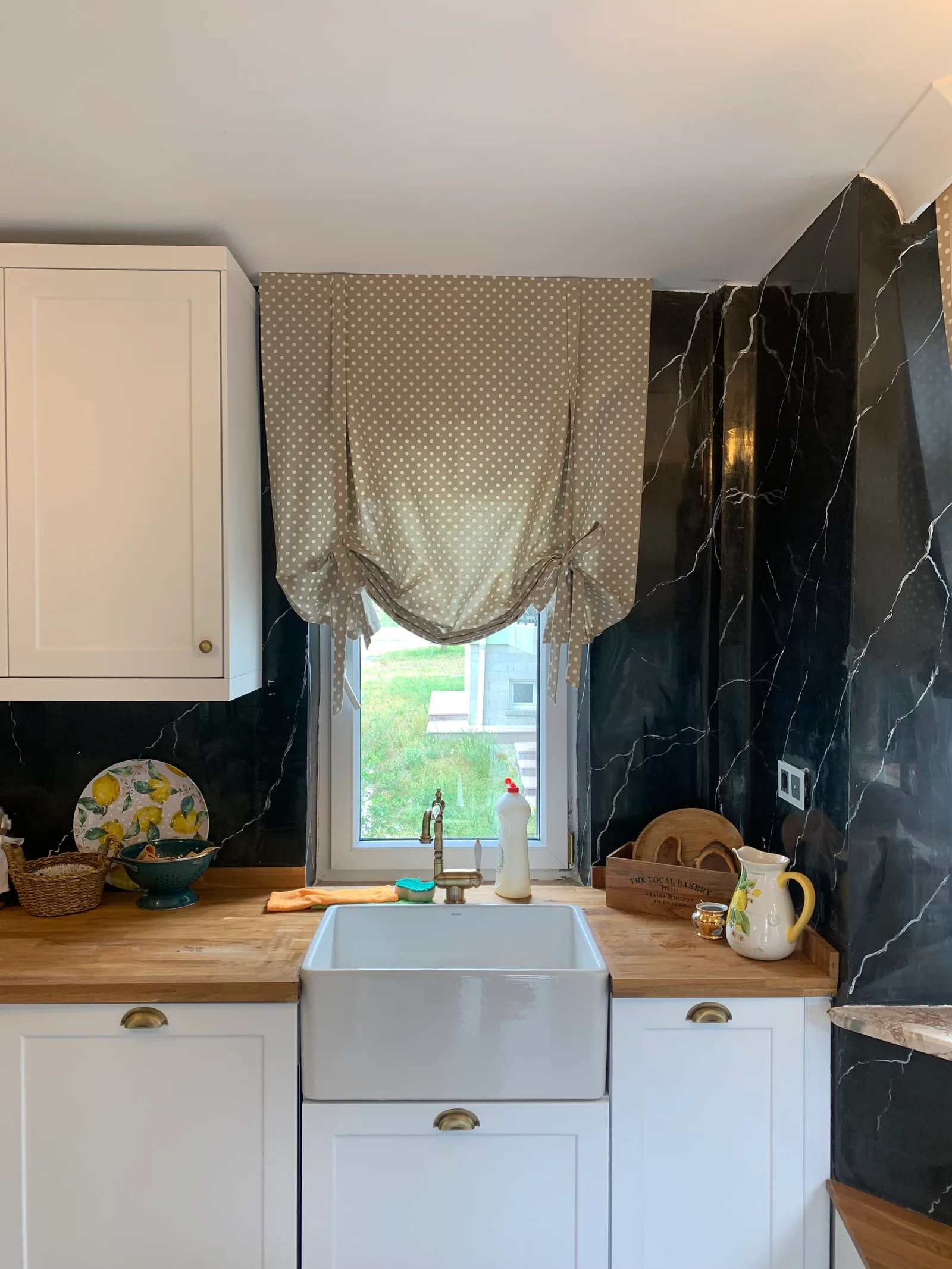 Beige polka-dot balloon curtain above a kitchen sink