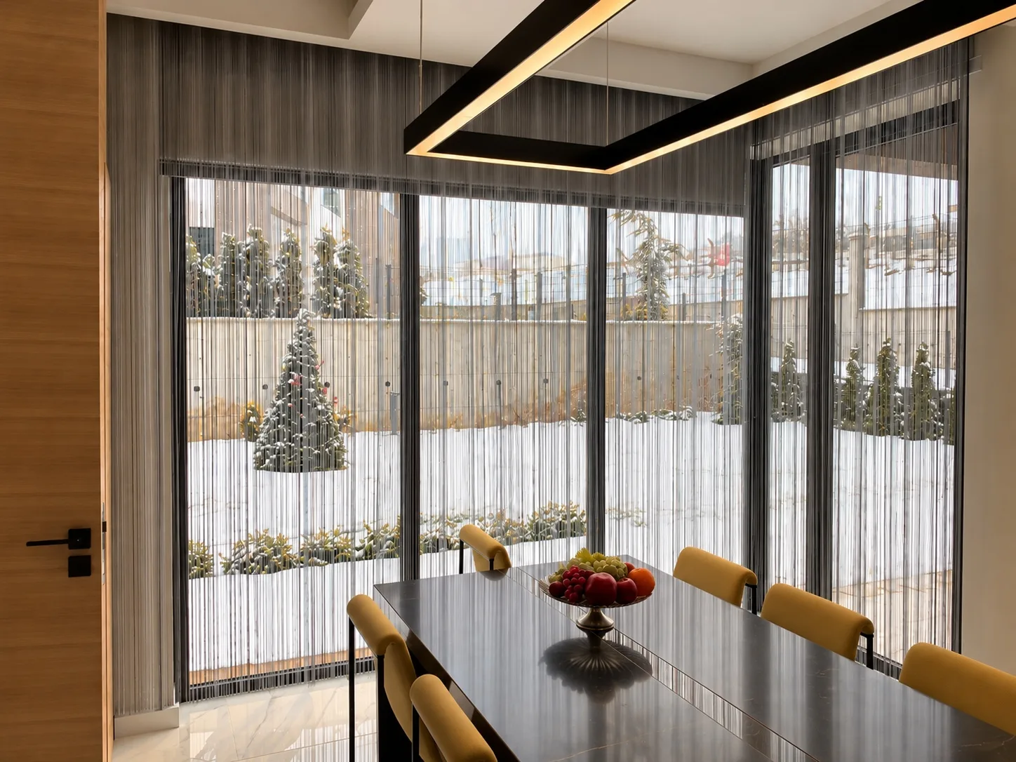 String curtains on corner windows in a dining area overlooking a snowy garden