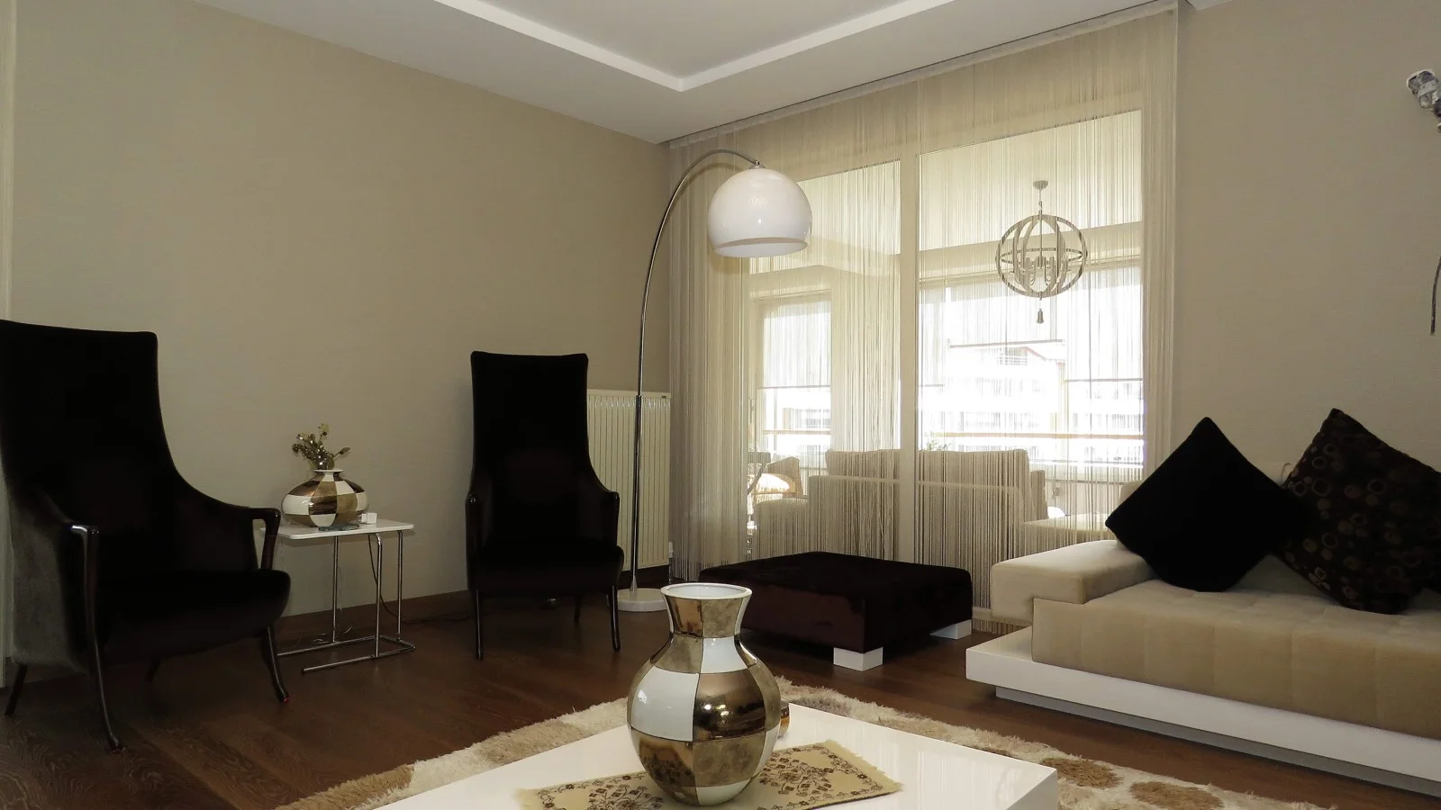 Light-coloured string curtains across a wide living-room window