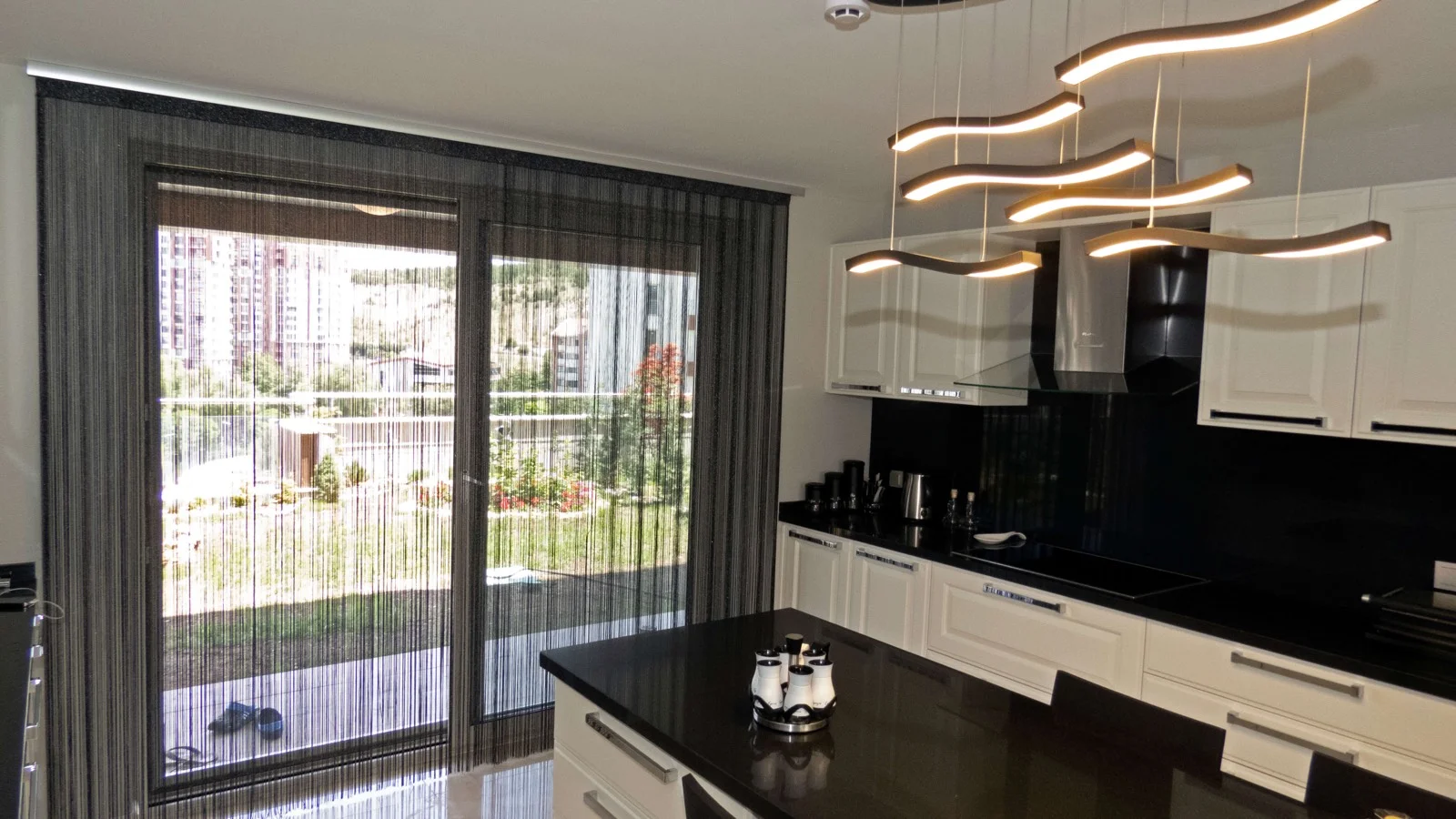 Dark string curtains in front of a kitchen window