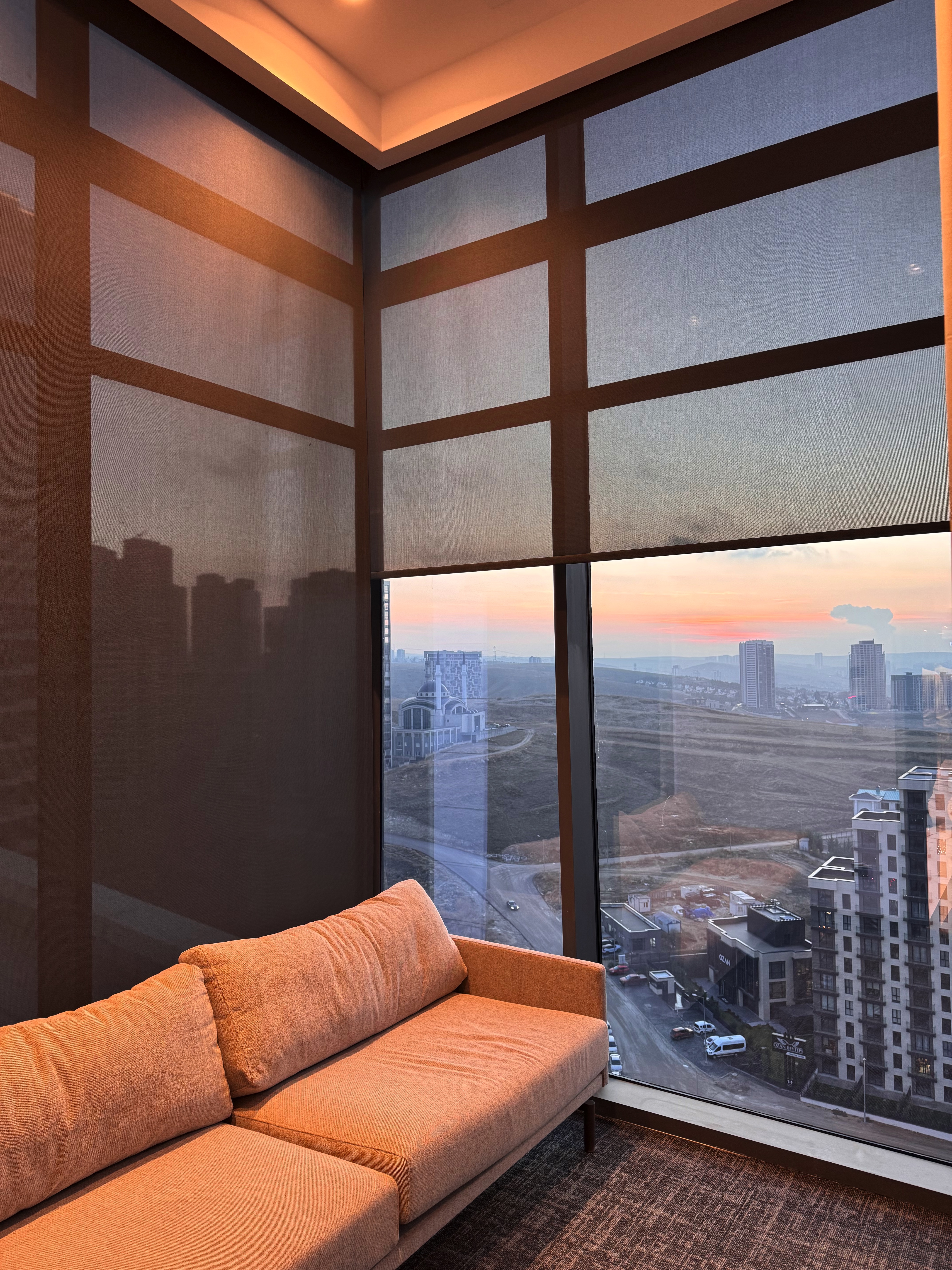Partially raised sunscreen roller blinds across the corner windows at Mira Ofis Beytepe