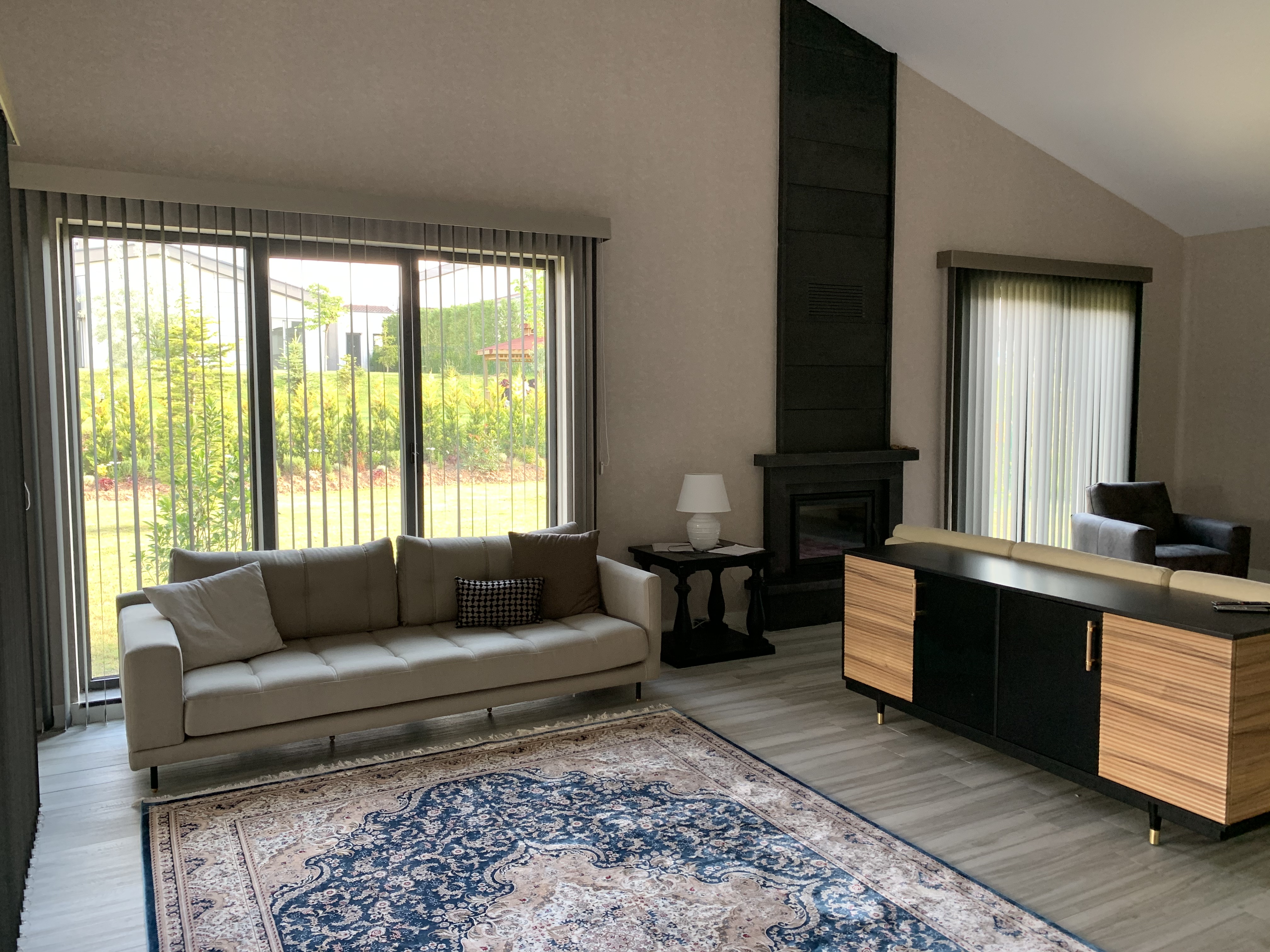 Villa Voga Gölbaşı salonunda iki pencere açıklığına uygulanan antrasit kumaş dikey perdeler