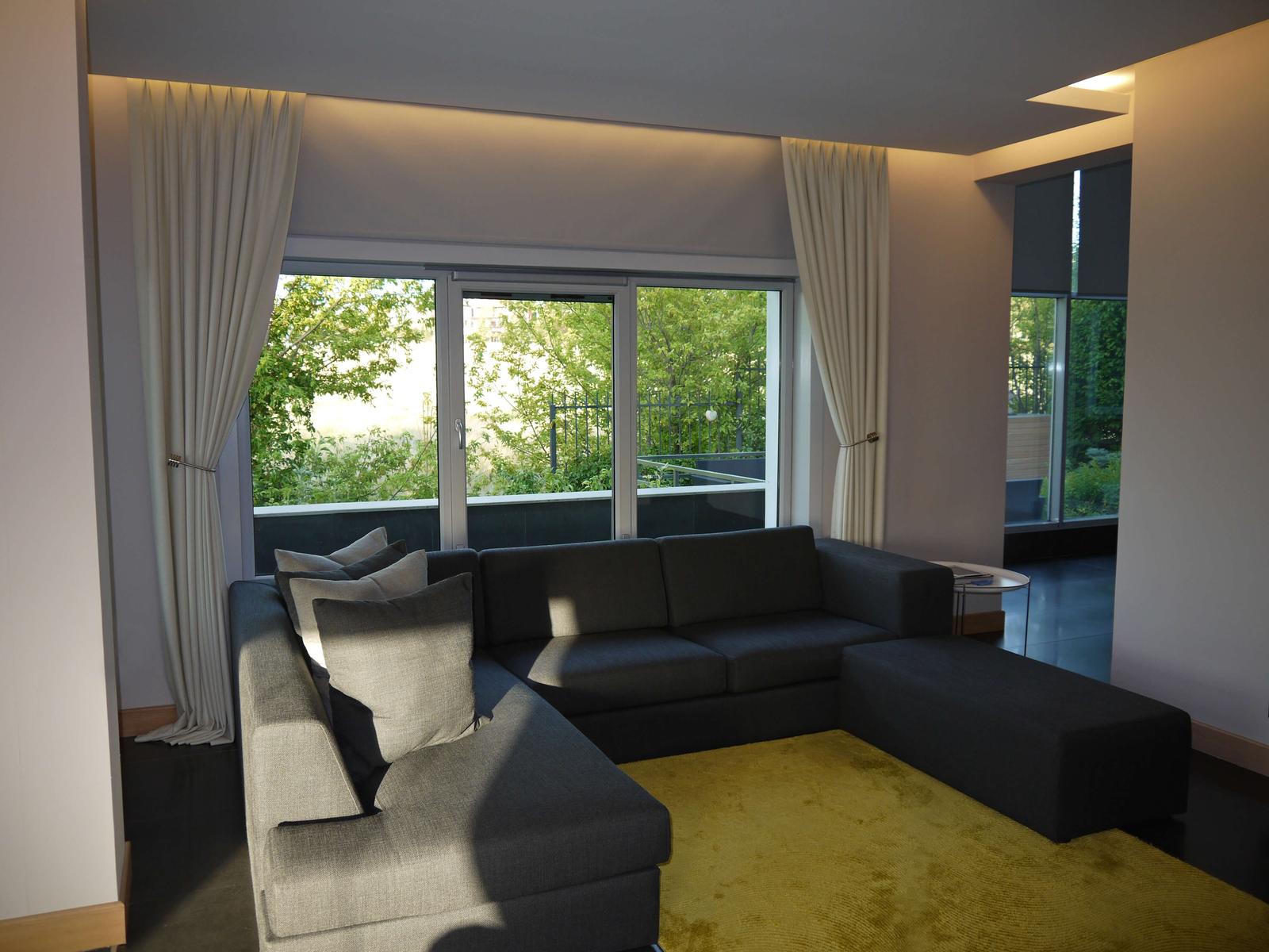 Pale fabric provides a calm vertical surface at a standard ceiling height.